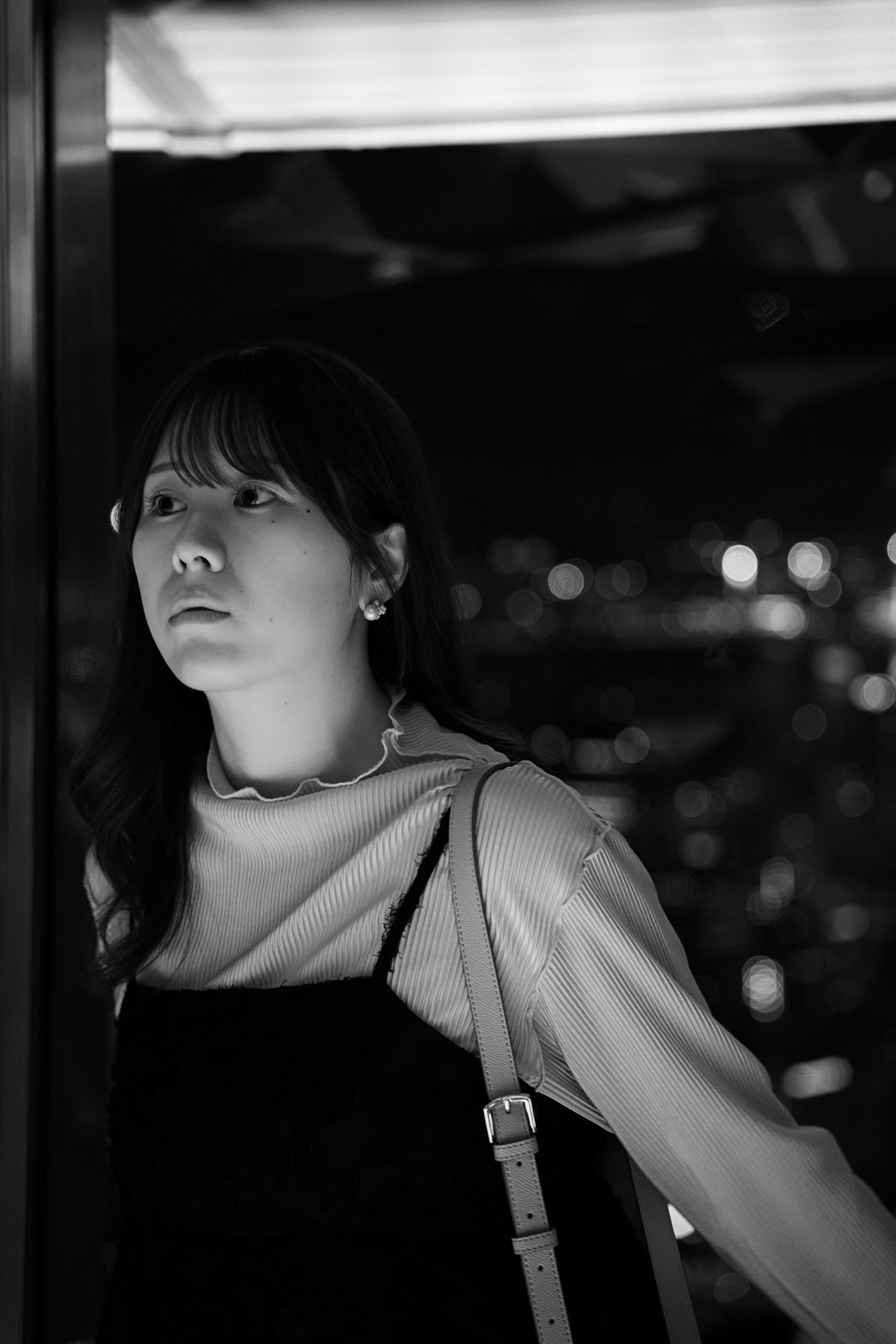 夜景の見える窓辺のモノクロのポートレート