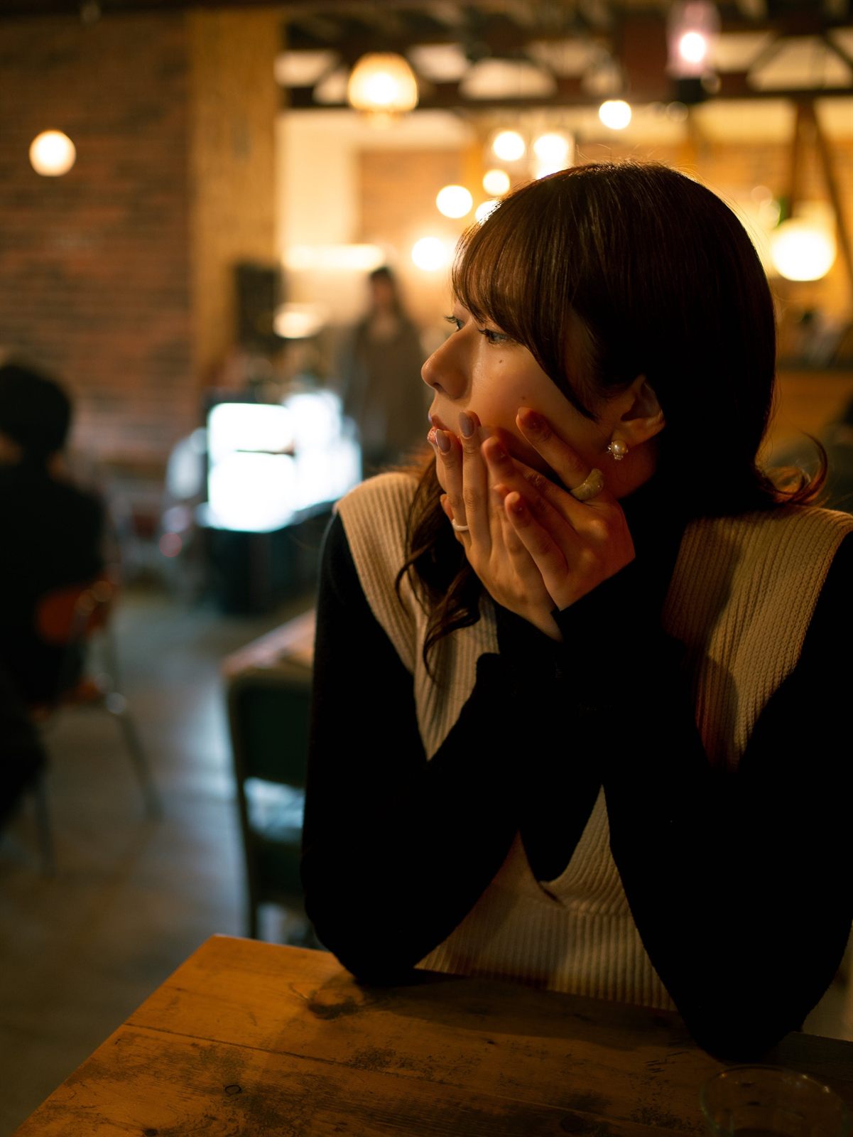 カフェで頬づえをつく女性