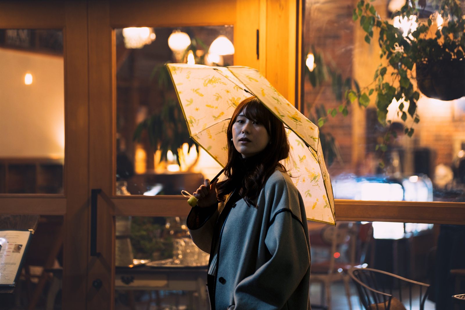 花柄の傘をさして立つ女性