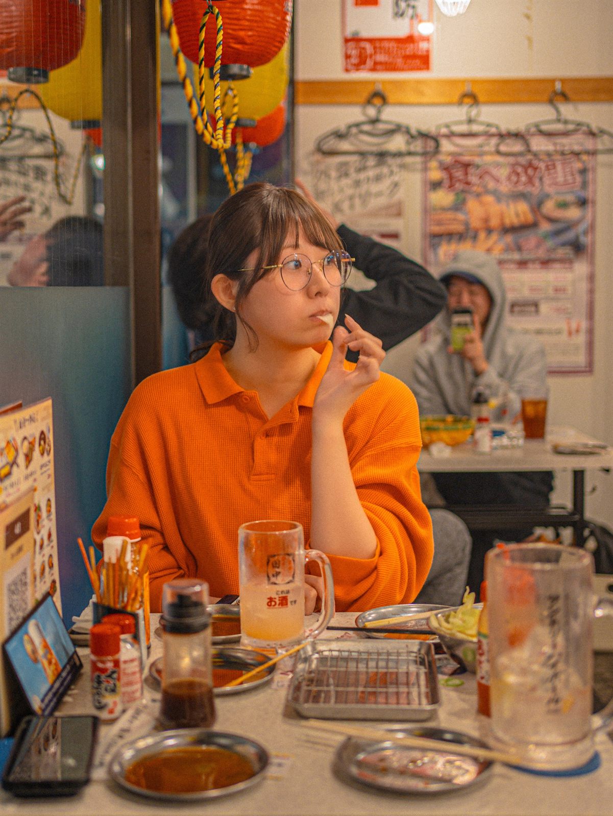 居酒屋の席で考えごとをする女性
